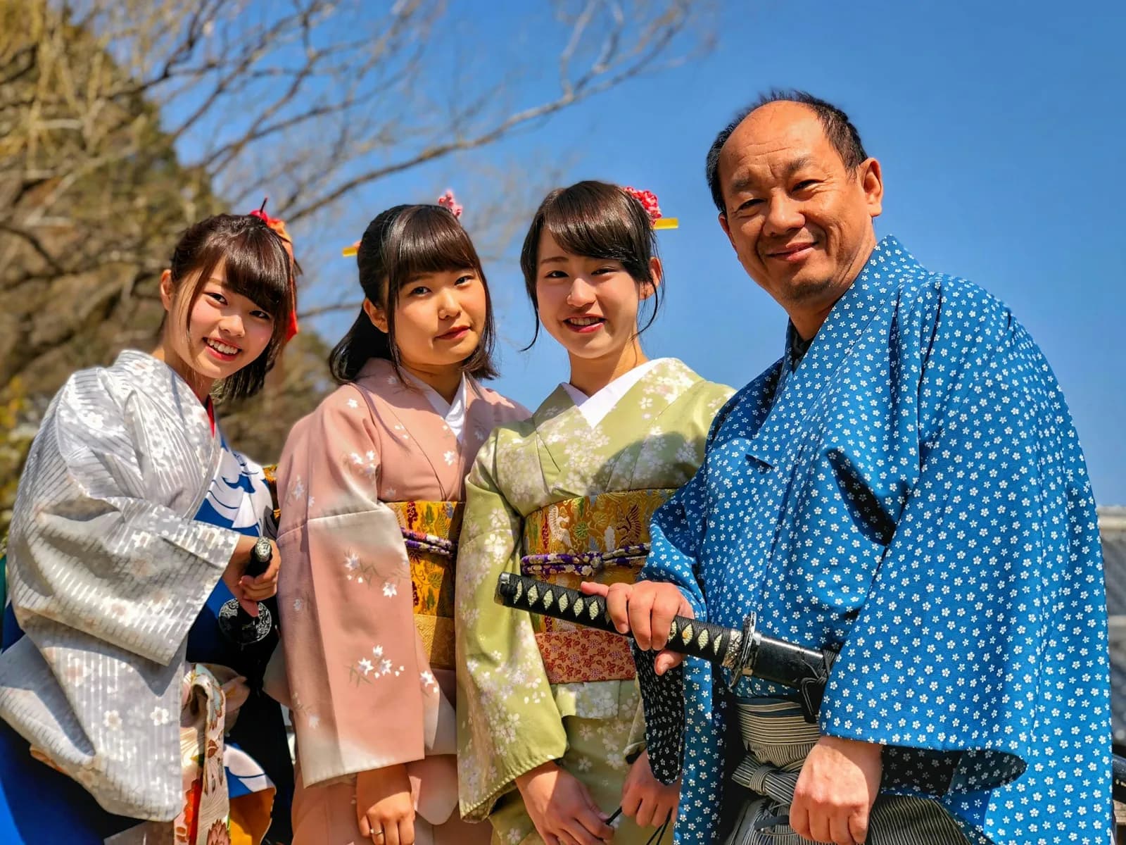 trois femmes en kimono et un homme avec un katana