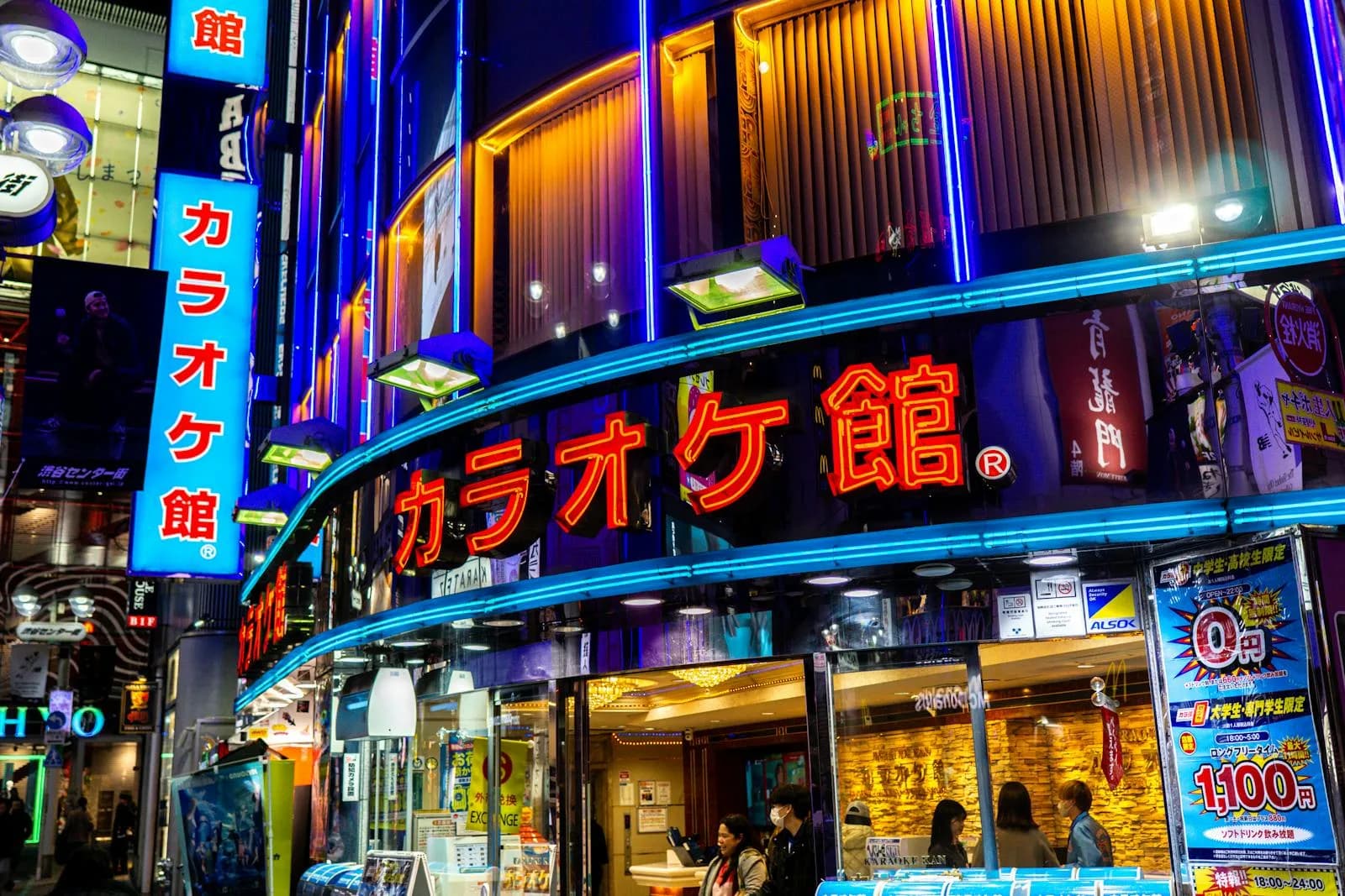 Explorez la vie nocturne animée de Tokyo avec des panneaux de néon vibrants dans une rue animée. Parfait pour les thèmes de la culture urbaine.