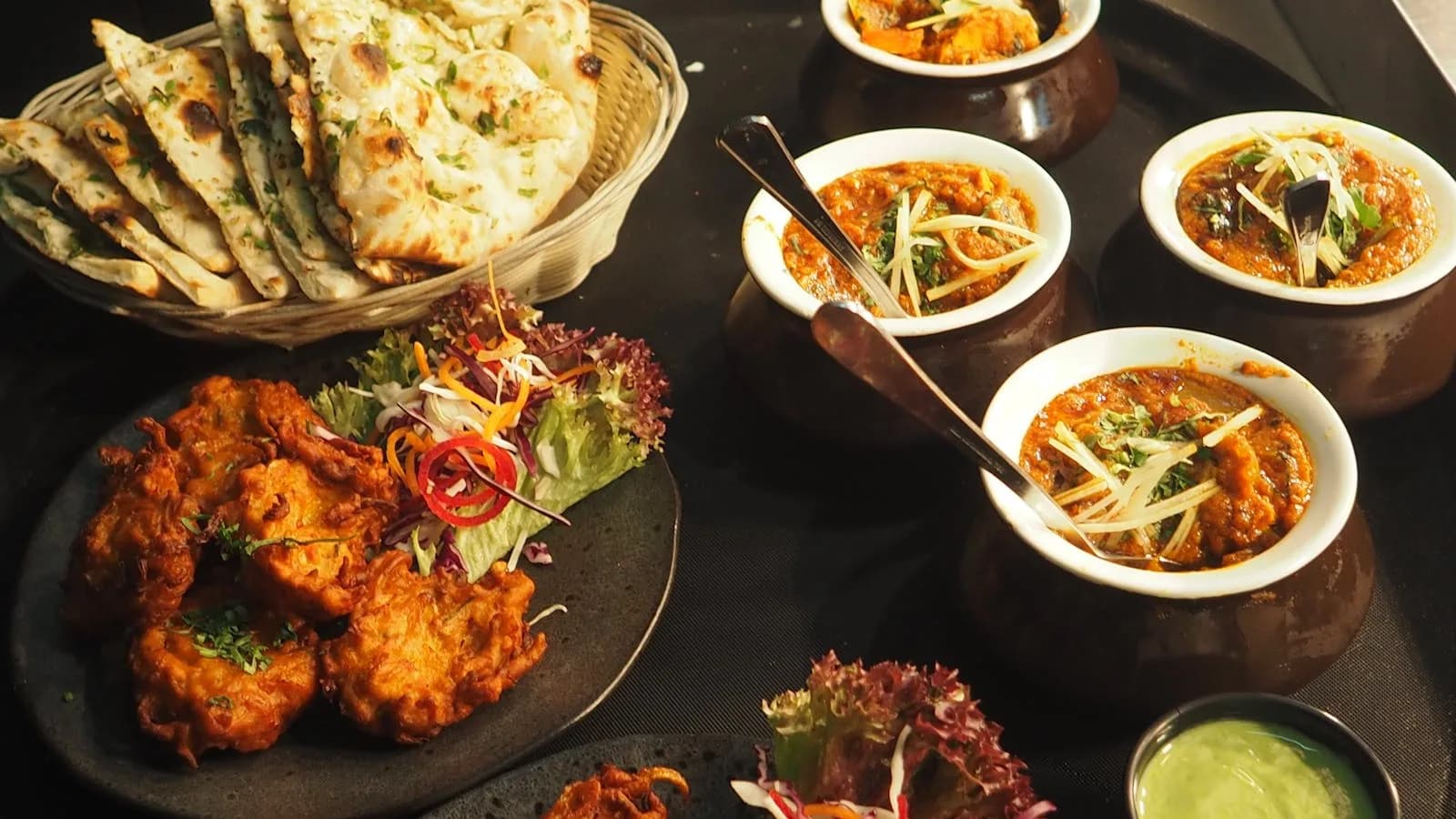 Une exposition alléchante de cuisine indienne avec naan, curry et pakoras parfait pour un repas délicieux.