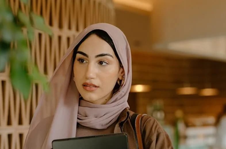 une femme tenant un ordinateur portable
