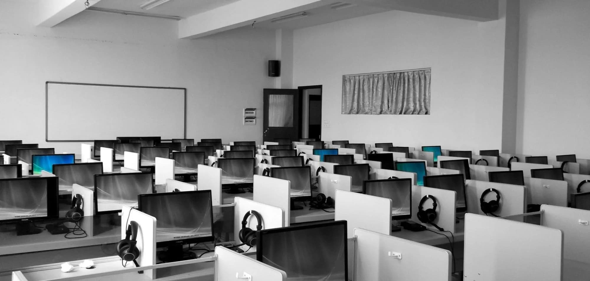 Salle informatique d'un établissement scolaire prête à accueillir des élèves de troisième pour la passation du test Ev@lang collège